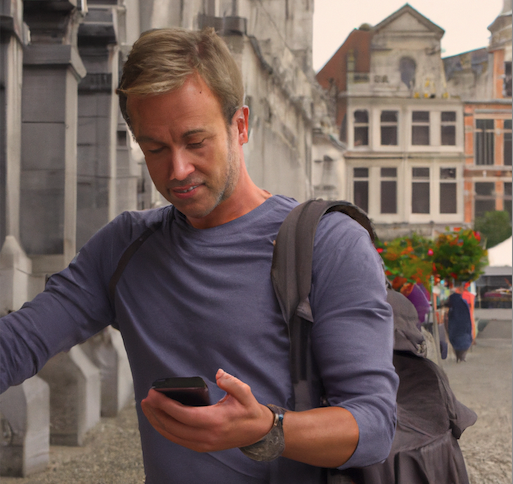 Best eSIM for Belgium: Top 6 cards to travel in 2023 3 traveler using an esim with his phone in Brussels, Belgium